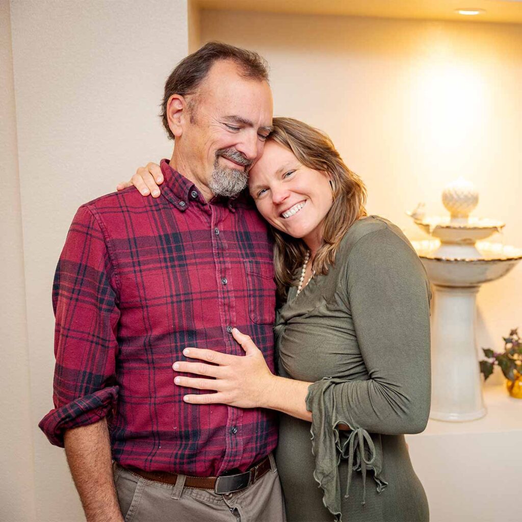 Couple embracing happily in a cozy setting.
