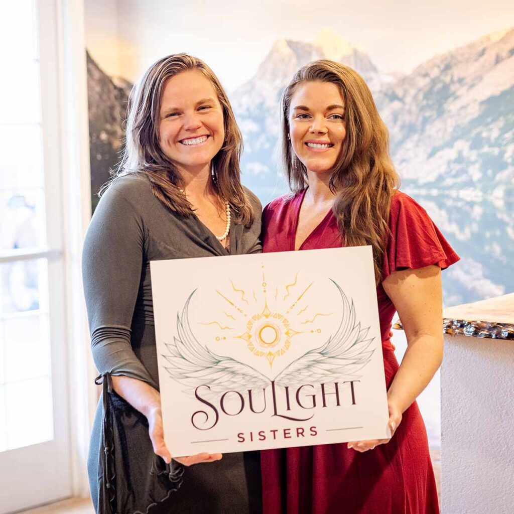 Two women holding SouLight Sisters sign